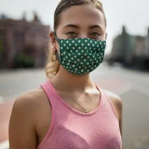 girl in pink tank top with green mask