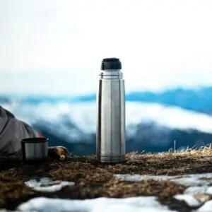 silver vacuum flask on brown dried grass